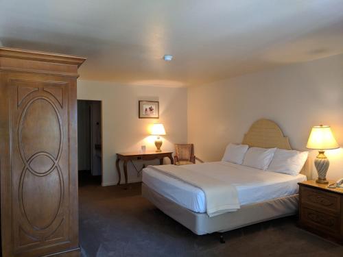 a bedroom with a large white bed and a table at Saddle West Casino Hotel in Pahrump