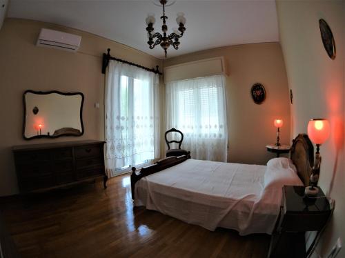 1 dormitorio con 1 cama grande y 2 ventanas en Zefyros Super Cool Apartments next to Alimos Riviera, en Atenas