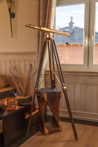 a tripod in a room with a telescope at Penthouse Meerblick in Dierhagen