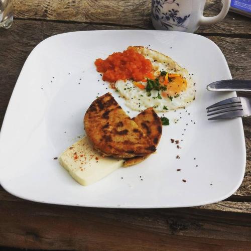 a white plate with an egg and toast and salsa at Jacamaki Nature GuestHouse en Villa de Leyva in Villa de Leyva