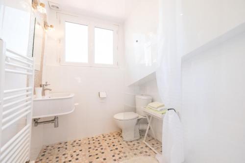 a white bathroom with a toilet and a sink at Petit studio Saint-Front- Small studio flat Saint-Front in Périgueux