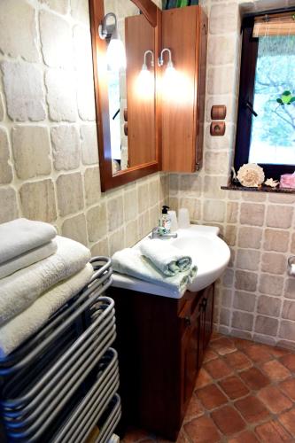 a bathroom with a sink and a mirror and towels at Leśna Strzecha Domek in Rotembark