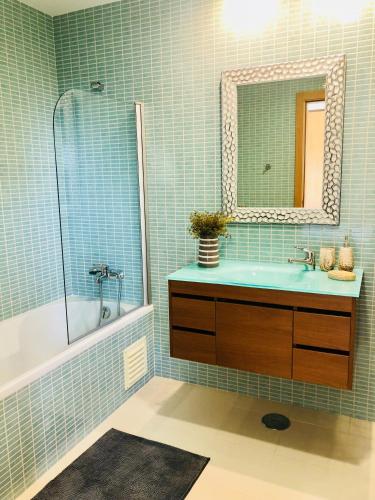 a bathroom with a sink and a mirror at Mar Alto,in Marina Village in Olhão