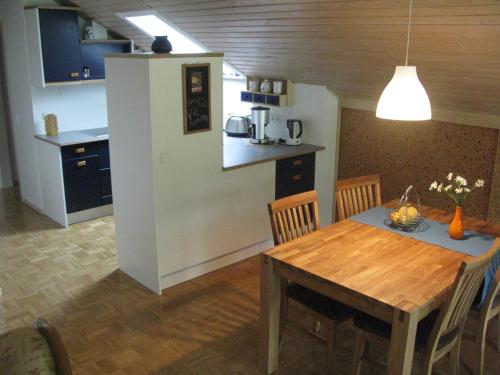 Il comprend une cuisine et une salle à manger avec une table en bois. dans l'établissement Ferienwohnung Zur Parmke, à Schmallenberg