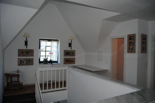 een witte kamer met een trap en een raam bij Bed and Breakfast Petra Huber in Vichtenstein