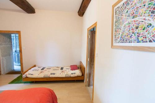 a bedroom with a bed and a painting on the wall at La Malinette B&B, calme et authenticité in Mâlain