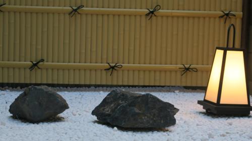 a lamp and two rocks in a room at UU Inn Kyoto in Kyoto