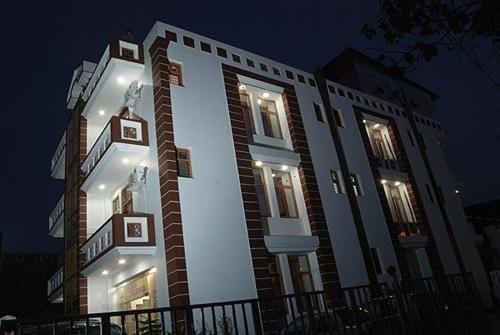 a large white building with lights on it at night at Hotel Galaxy in Dehradun