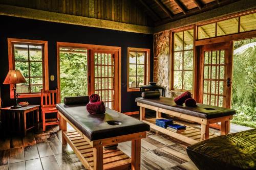 a living room with two tables and windows at Matisses Hotel & Spa in Santa Rosa de Cabal