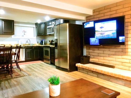 a kitchen with a tv on a brick wall at Spruce Moose Mtn Retreat w Sauna 11 Miles to World Class Ski in Sandy