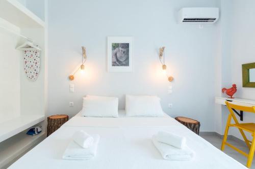 1 dormitorio con cama blanca y escritorio en Rodamos apartment, en Ierápetra