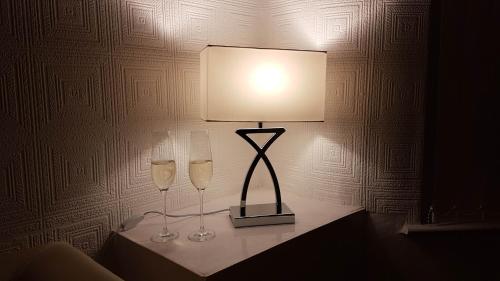 a lamp with two wine glasses on a table at 39 Cowley Road in Liverpool