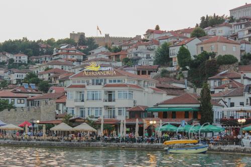 a large body of water with houses and boats at Hotel Aleksandrija in Ohrid