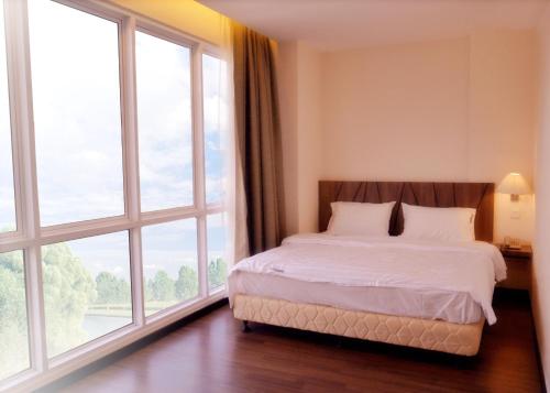 1 dormitorio con 1 cama y ventanas grandes en 9 Square Hotel - Petaling Jaya, en Kota Damansara