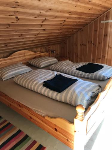 two beds in a room with wooden walls at Charming Lakeside House with sauna in Lillehammer