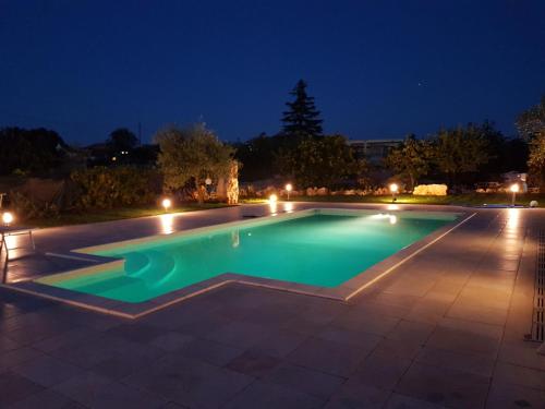una piscina notturna con luci di Trullo suite 59 a Noci