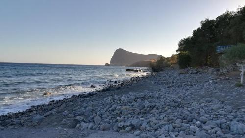 a large group of rocks on a beach at Sofia Apartment in Léntas