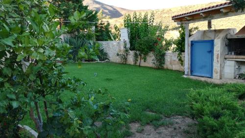 a garden with a blue door in a yard at Sofia Apartment in Léntas