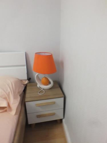 a lamp on a night stand next to a bed at Residence Miranto in Châteauroux