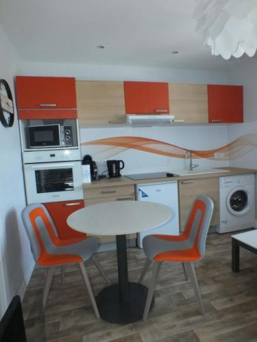a kitchen with a table and chairs in a kitchen at Residence Miranto in Châteauroux