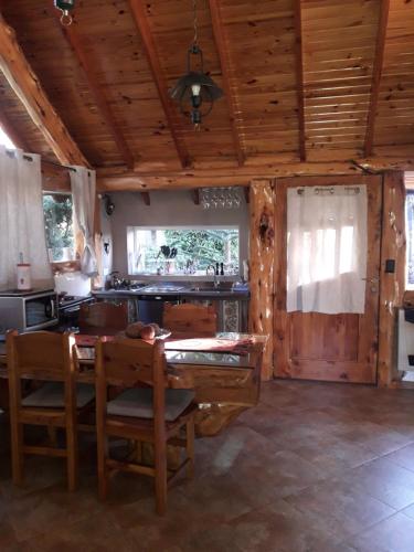 Il comprend une cuisine équipée d'une table à manger et d'une cuisinière. dans l'établissement Cabaña Tibor, à San Carlos de Bariloche