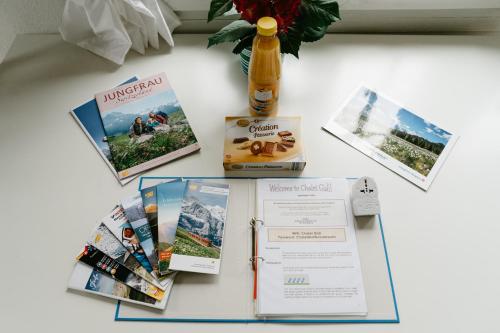 a table topped with brochures and a bottle of beer at Amazing Apartment EIGER Grindelwald in Grindelwald