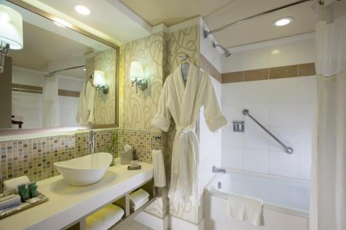 a bathroom with a sink and a mirror and a tub at Barcelo Guadalajara in Guadalajara