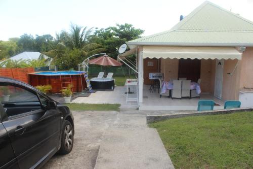 a car parked in front of a house at Villa Kapiopa in Sainte-Anne