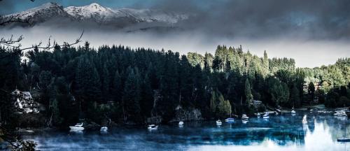 a group of boats on a lake with a mountain at Marinas Alto Manzano in Villa La Angostura