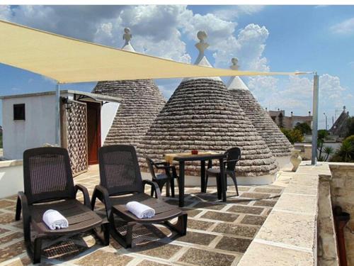 a patio with chairs and a table and a tent at Agriturismo Grotta Di Figazzano in Cisternino