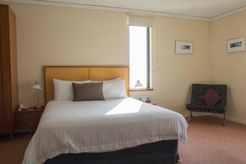 a bedroom with a large bed and a window at Ocean Beach Hotel in Perth