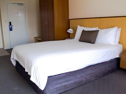 
a hotel room with a bed and a desk at Ocean Beach Hotel in Perth
