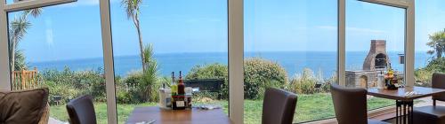 a dining room with a table and a view of the ocean at Villa Mentone Hotel in Shanklin