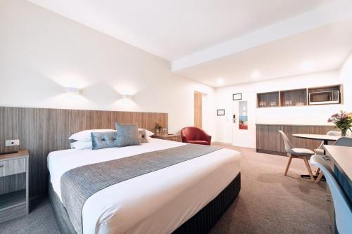 a hotel room with a large bed and a table at Club Laverton in Laverton