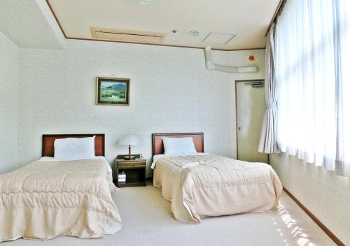 A bed or beds in a room at Itoen Hotel Shikisai