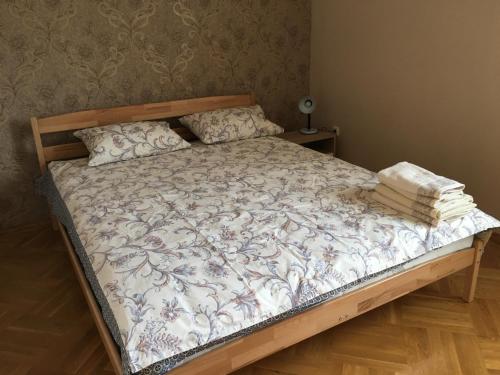 ein Schlafzimmer mit einem Bett mit einem Holzrahmen in der Unterkunft олан in Truskawez