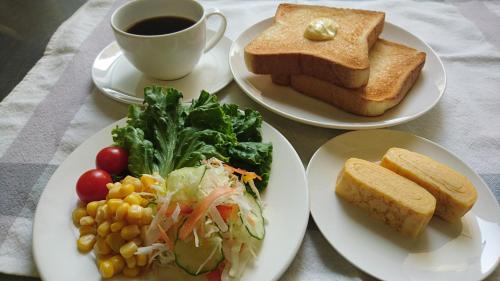 a table with plates of food and a cup of coffee at Hotel Taiheiyo in Matsushige