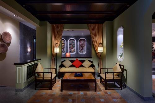 a living room with a couch and two chairs at Little Riverside Hoi An . A Luxury Hotel & Spa in Hoi An