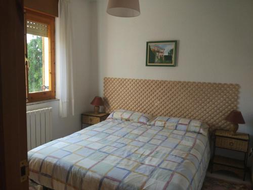 um quarto com uma cama e duas mesas de cabeceira com dois candeeiros em Chalet en el Orbigo em La Bañeza