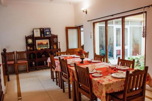 a dining room with a table and chairs and a window at Devra Udaipur in Udaipur