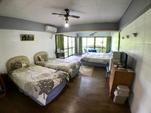 a room with two beds and a flat screen tv at Surfside Bed & Breakfast in Onna