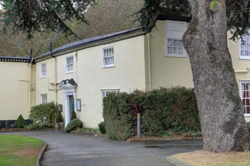 a white house with a tree in front of it at The Cedars Hotel in Stowmarket