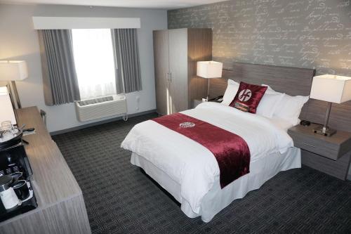 a large hotel room with a large bed and two windows at Hartford Hotel Best Western Signature Collection in Rosemead