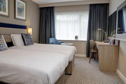 a hotel room with a bed and a desk and a window at Linton Lodge a BW Signature Collection Hotel in Oxford