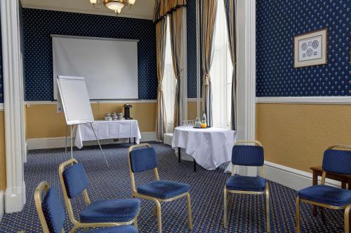 a room with a table and chairs and a white board at Best Western Queens Hotel in Dundee