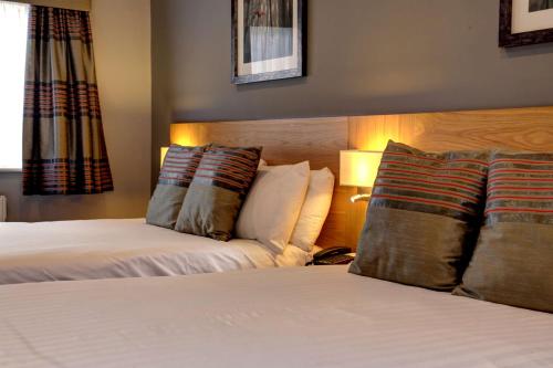 a hotel room with two beds and two pillows at Linton Lodge a BW Signature Collection Hotel in Oxford