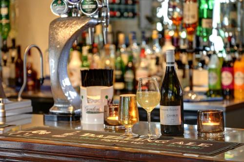 a bar with a bottle of wine and two glasses at Best Western Plus Milford Hotel in South Milford
