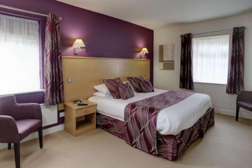 a hotel room with a bed and a chair at Best Western Plus Sheffield Mosborough Hall Hotel in Sheffield