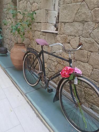 a bike parked next to a wall with flowers on it at Kazdaglari Karye Müze Hotel in Kucukkuyu