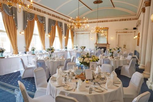 a banquet hall with white tables and white chairs at Best Western Lichfield City Centre The George Hotel in Lichfield